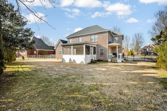 back of house featuring a sunroom and a lawn