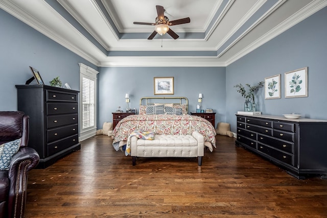 bedroom with dark hardwood / wood-style flooring, a tray ceiling, ornamental molding, and ceiling fan