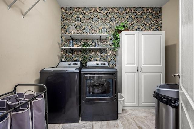 washroom with washer and clothes dryer and cabinets