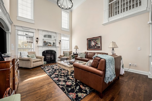 living room featuring dark wood-type flooring, ornamental molding, and plenty of natural light