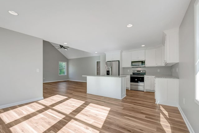 kitchen with a kitchen island with sink, stainless steel appliances, white cabinets, and light wood-type flooring