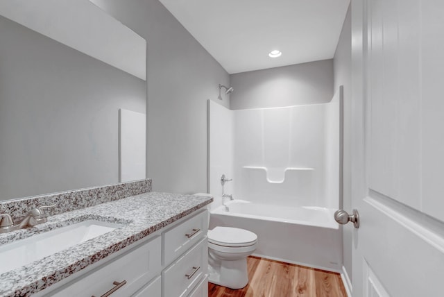 full bathroom featuring vanity, hardwood / wood-style floors, shower / tub combination, and toilet