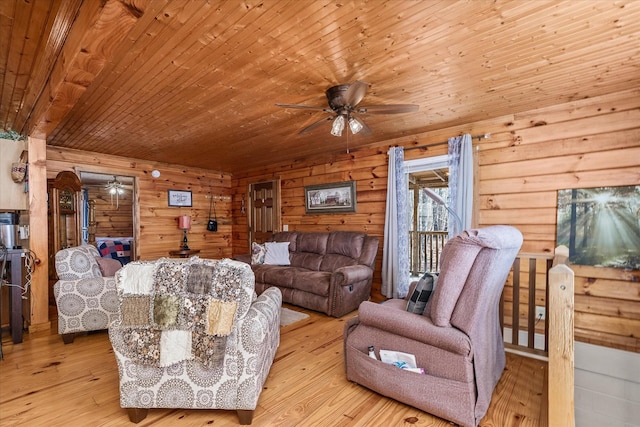 living room with wood ceiling, ceiling fan, wooden walls, and light hardwood / wood-style flooring