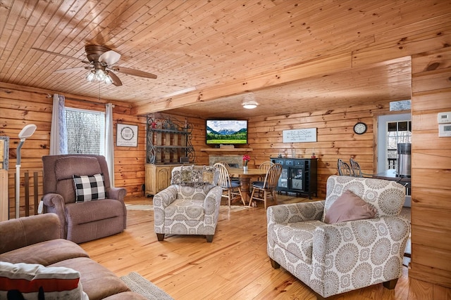 living room with wooden walls, wooden ceiling, ceiling fan, and light wood-type flooring