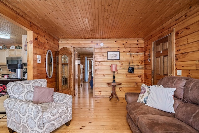 living room featuring wood walls, light hardwood / wood-style floors, and wooden ceiling