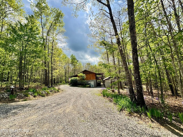 907 Parkstown Ext, Wilder, TN 38589 - view of front facade with an outdoor structure, gravel driveway, and a forest view