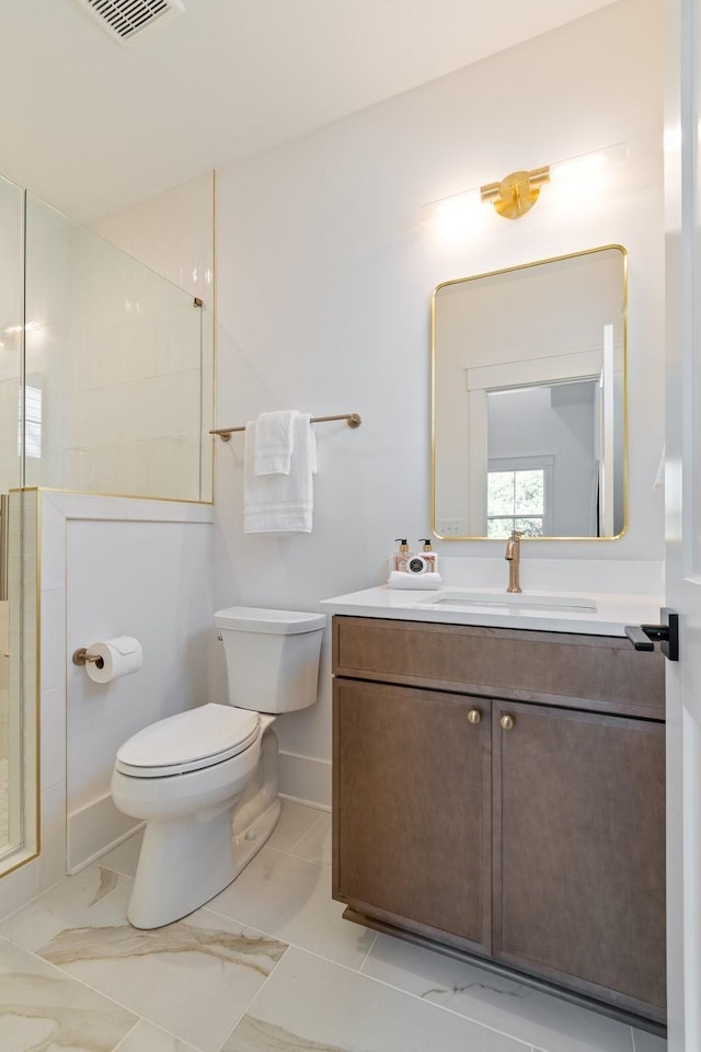 bathroom with an enclosed shower, vanity, and toilet