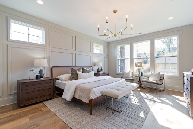 bedroom with an inviting chandelier and light hardwood / wood-style floors