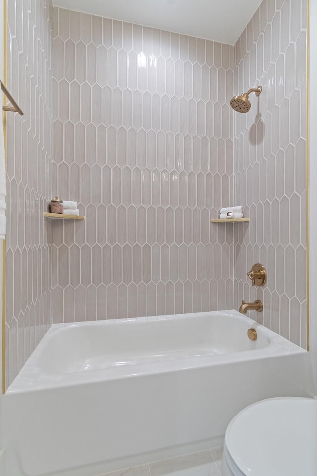 bathroom featuring toilet and tiled shower / bath combo