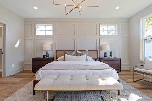 bedroom featuring an inviting chandelier and wood-type flooring