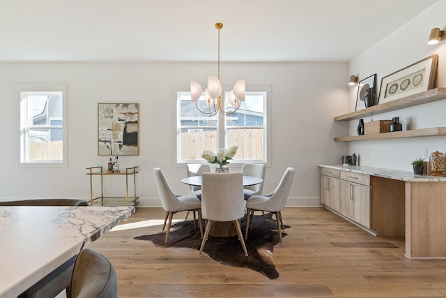 dining area featuring a notable chandelier and light hardwood / wood-style floors