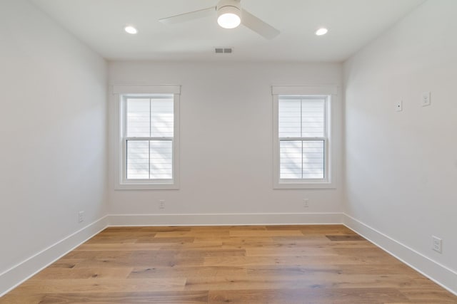 empty room with ceiling fan and light hardwood / wood-style floors