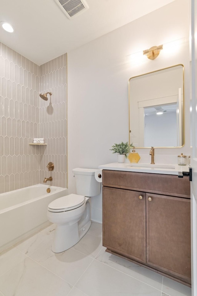 full bathroom featuring vanity, tiled shower / bath combo, and toilet