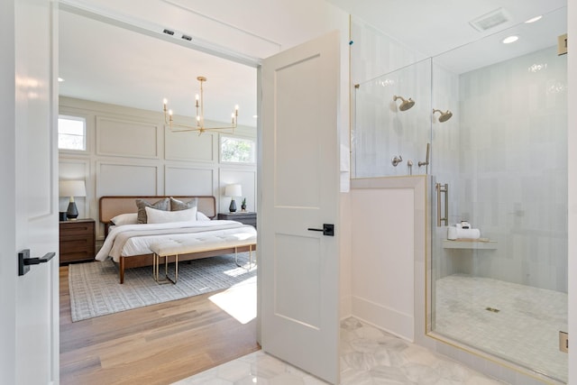 bedroom featuring a chandelier and light hardwood / wood-style floors