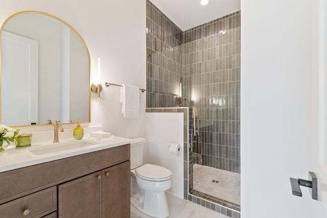 bathroom featuring vanity, toilet, and tiled shower