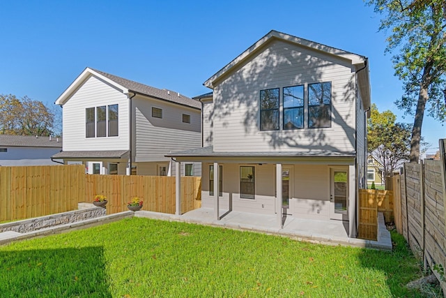 rear view of house with a patio and a lawn