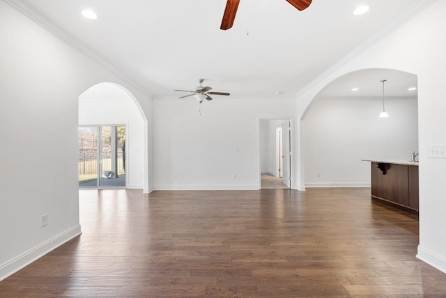 unfurnished living room featuring crown molding, dark hardwood / wood-style floors, and ceiling fan