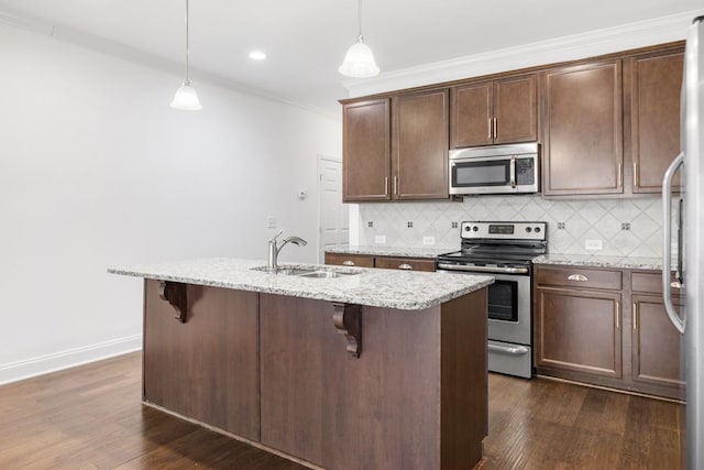 kitchen featuring an island with sink, appliances with stainless steel finishes, sink, and pendant lighting