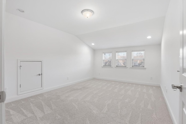 carpeted empty room with lofted ceiling