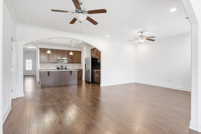 unfurnished living room with ornamental molding, dark hardwood / wood-style floors, and ceiling fan