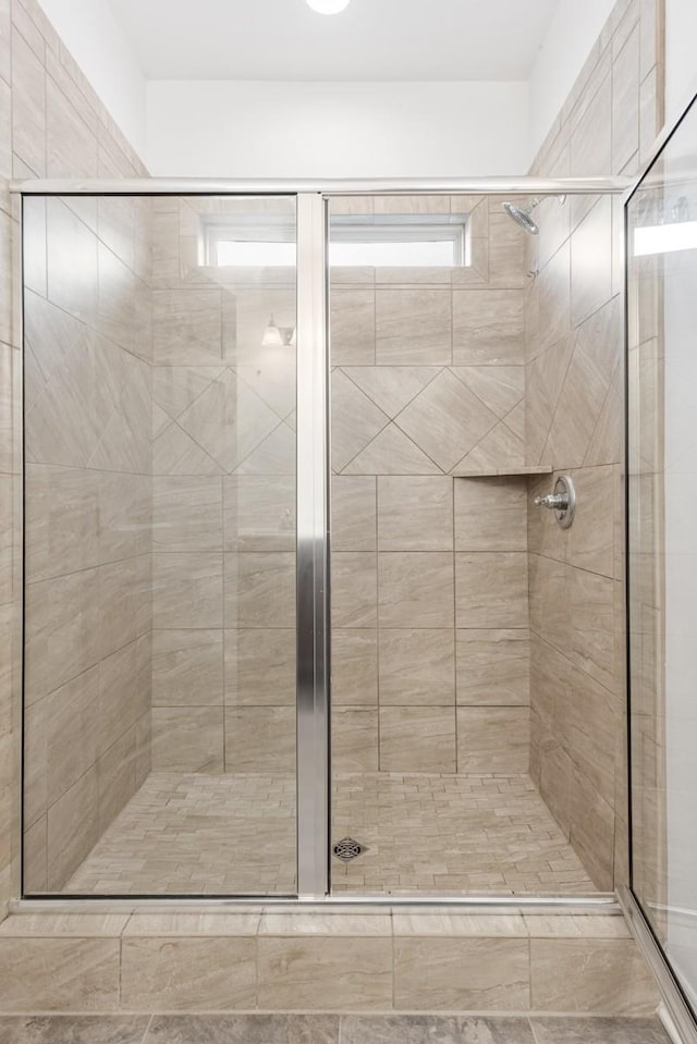 bathroom featuring a shower with door