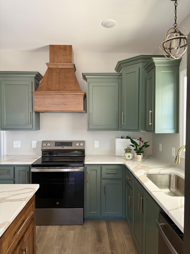 kitchen featuring stainless steel appliances, premium range hood, a sink, and green cabinetry