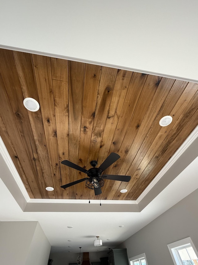 room details with ceiling fan, wood ceiling, and a raised ceiling