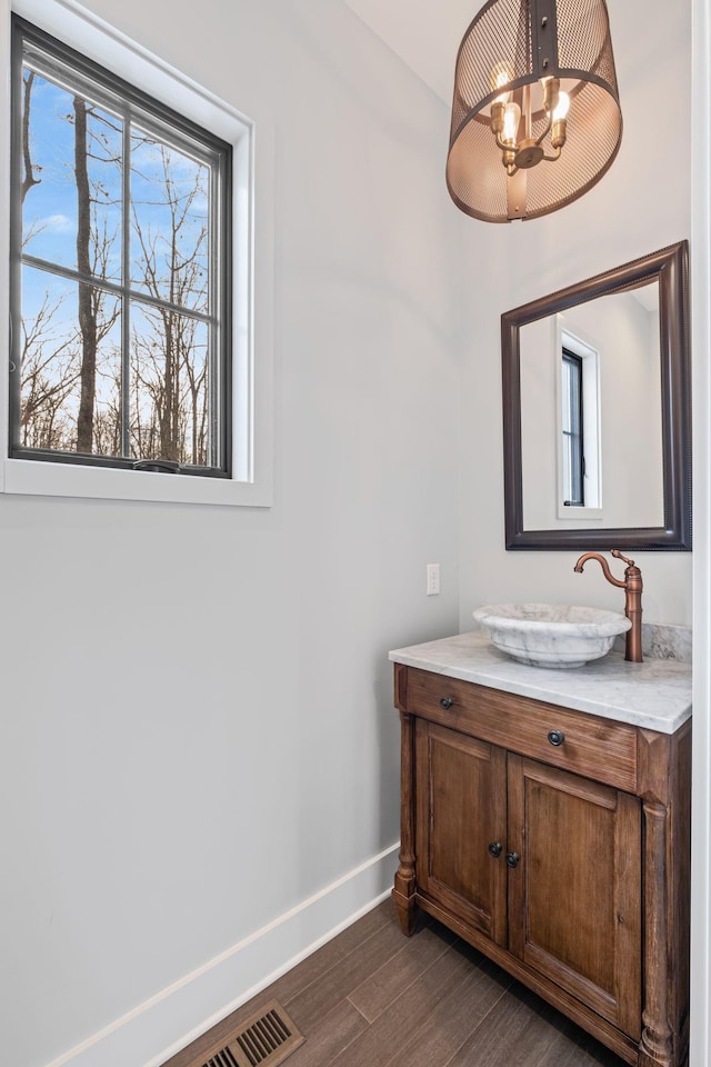 bathroom with a notable chandelier, wood-type flooring, and vanity