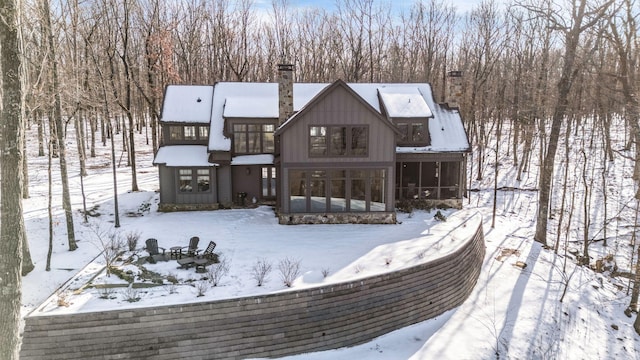 snow covered property with a sunroom