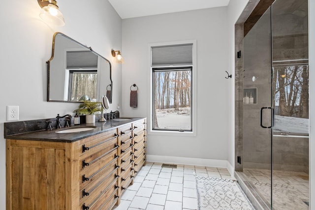 bathroom with walk in shower, vanity, tile patterned flooring, and a wealth of natural light