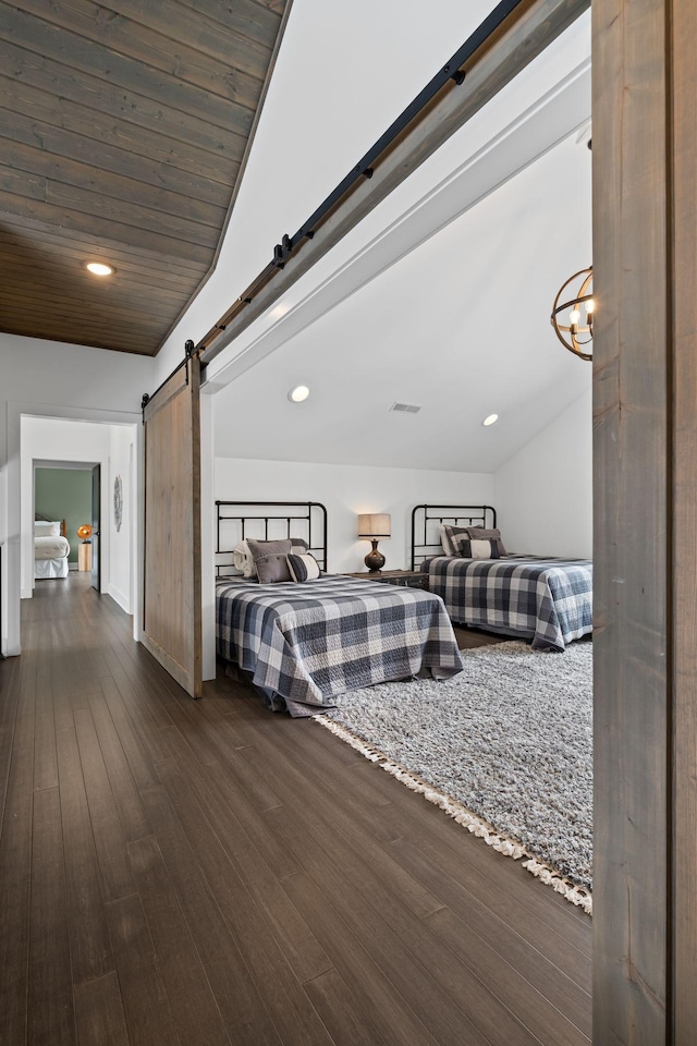 bedroom featuring lofted ceiling, dark wood-type flooring, wooden ceiling, and a barn door