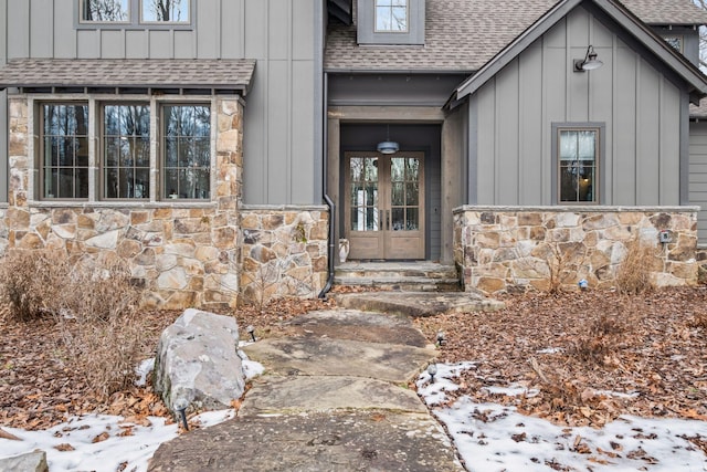 snow covered property entrance featuring french doors