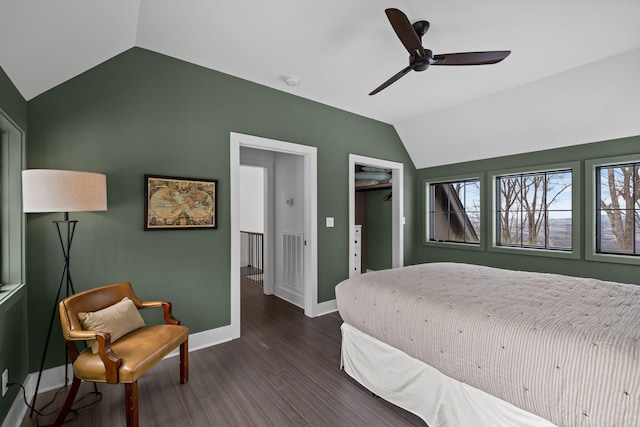 bedroom with dark wood-type flooring, vaulted ceiling, and ceiling fan