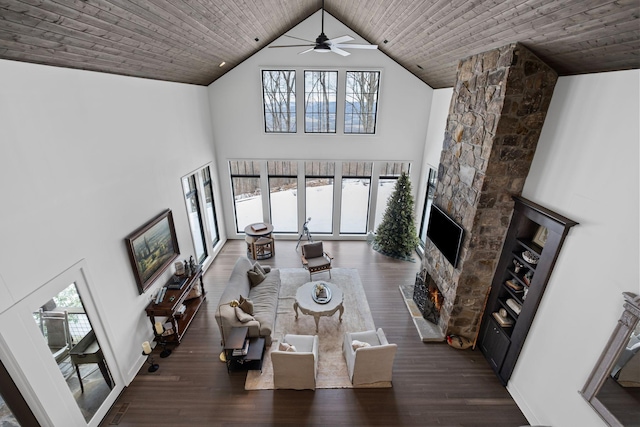 living room featuring dark hardwood / wood-style flooring, a stone fireplace, high vaulted ceiling, and wooden ceiling