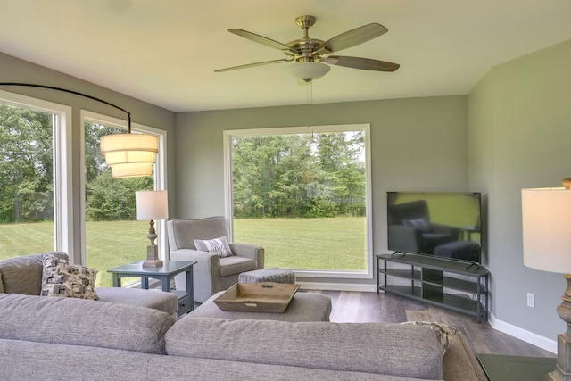 living room featuring dark wood-type flooring and ceiling fan