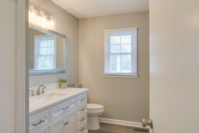 bathroom with hardwood / wood-style flooring, vanity, and toilet