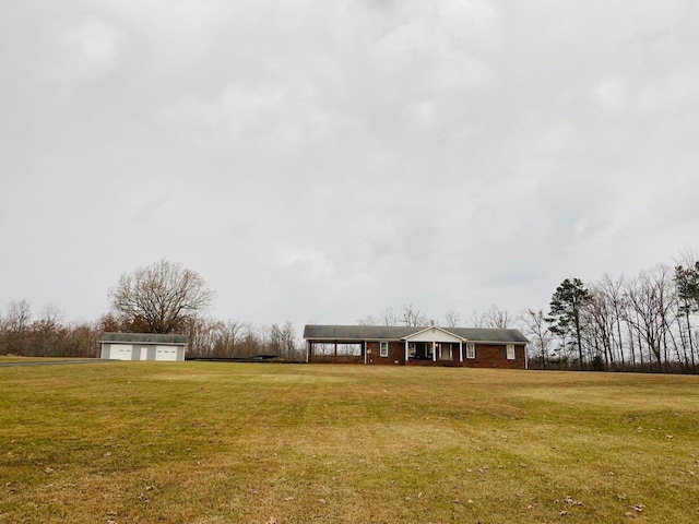 view of yard with an outbuilding, a carport, and a detached garage