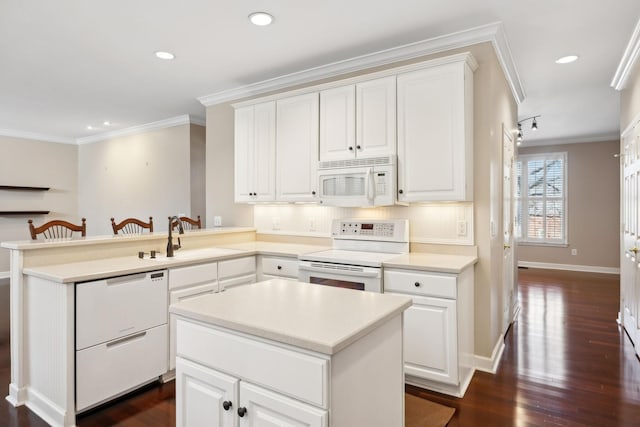 kitchen with sink, white cabinets, white appliances, and kitchen peninsula