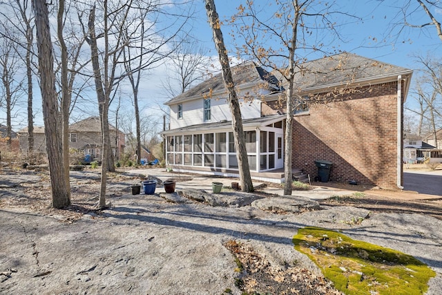 back of property with a sunroom