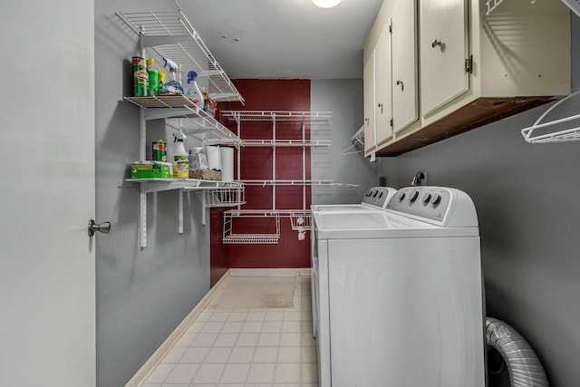 laundry area featuring light tile patterned floors, cabinets, and washing machine and clothes dryer