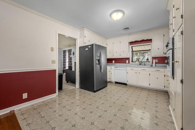 kitchen with stainless steel refrigerator with ice dispenser, sink, crown molding, dishwasher, and white cabinets