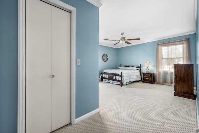 bedroom with light carpet, ornamental molding, a closet, and ceiling fan