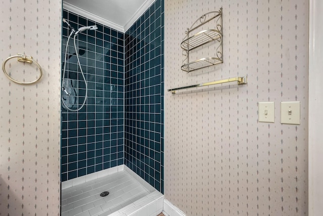 bathroom with a tile shower and crown molding