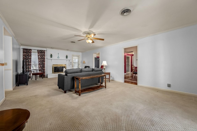 carpeted living room featuring crown molding, a large fireplace, and ceiling fan