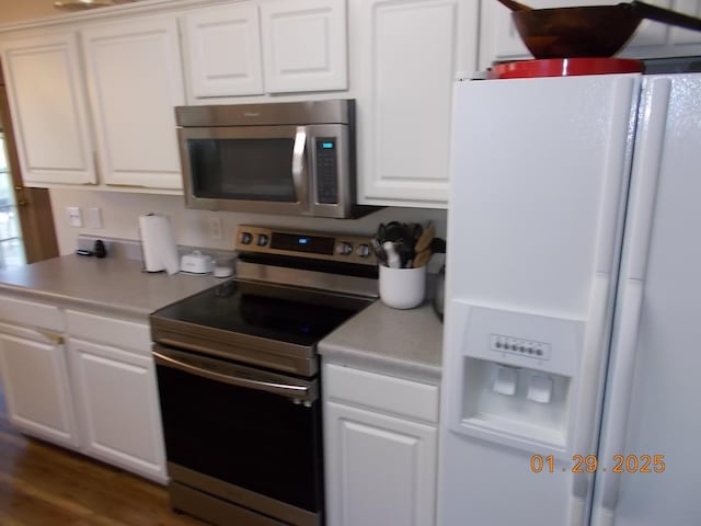 kitchen featuring white cabinetry, dark hardwood / wood-style flooring, and appliances with stainless steel finishes