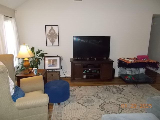 living room featuring hardwood / wood-style flooring and vaulted ceiling