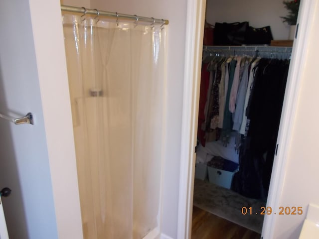 bathroom featuring wood-type flooring and a shower with curtain