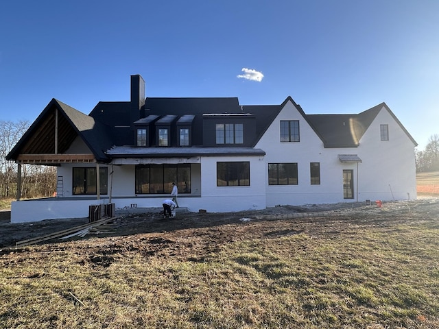 rear view of property featuring a chimney