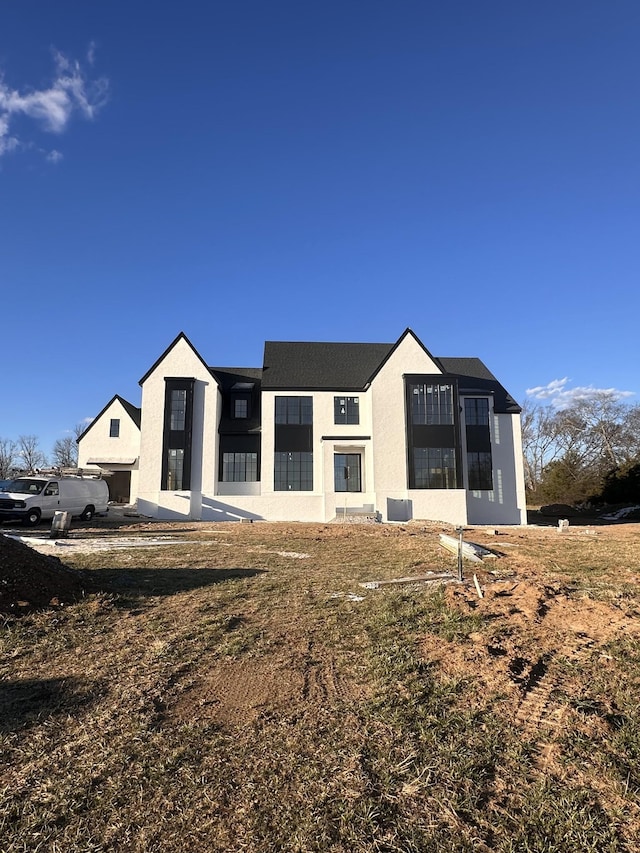 rear view of house with central AC unit and stucco siding