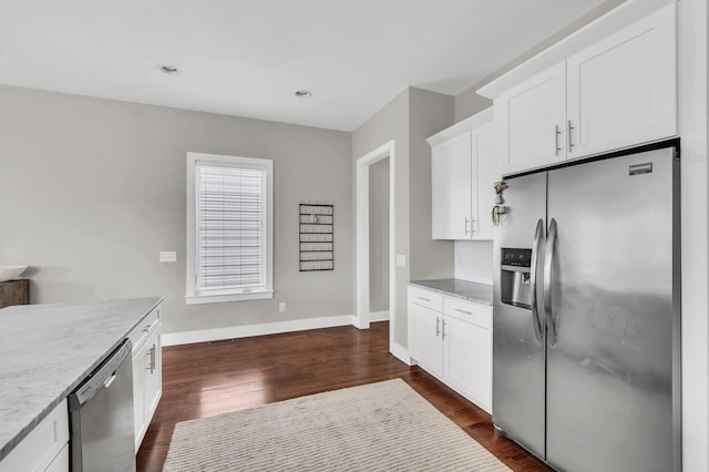 kitchen featuring stainless steel appliances, white cabinetry, dark hardwood / wood-style flooring, and light stone counters